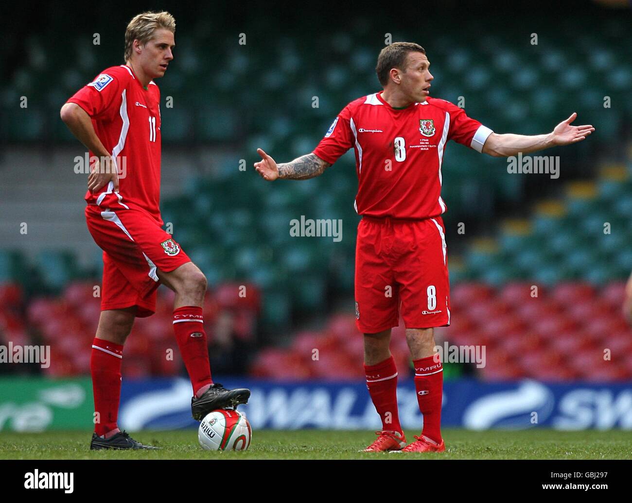 Craig Bellamy von Wales (rechts) zeigt seine Gesten als Teamkollege David Edwards (links) Wartet auf Neustart nach dem Punktestand in Finnland Stockfoto