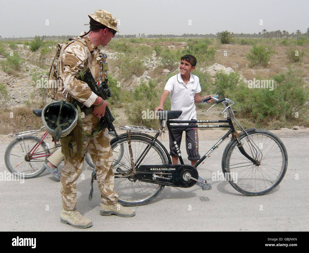 Major Jim Faux, von A-Company, 5 Gewehre, begrüßt einen jungen Jungen außerhalb von Al-Hartha, nördlich von Basra, Irak. Stockfoto