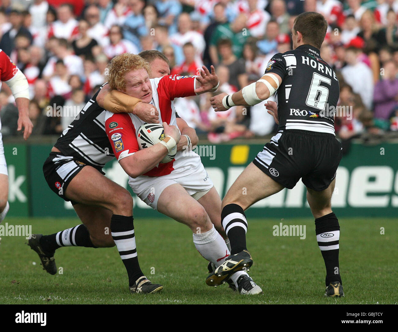 St Helens' James Graham (Mitte) wird von Hulls Jamie Thackray (links) und Richard Horne während des Engage Super League-Spiels in der Knowsley Road, St Helens, angegangen. Stockfoto