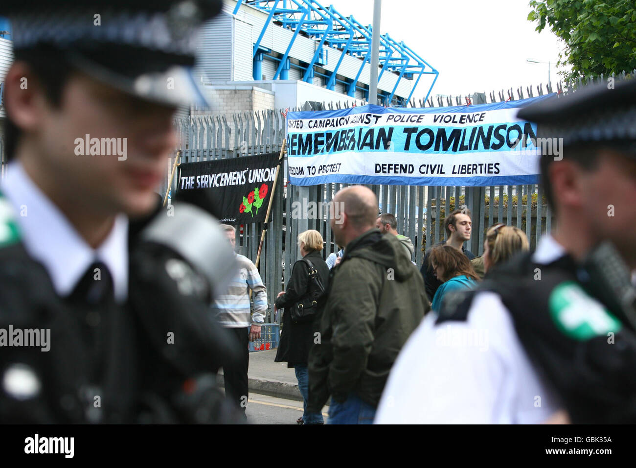 Polizeibeamte kommen an einem Banner vorbei, das von der United Campaign Against Police Violence vor dem New Den in Millwall im Südosten Londons aufgehängt wurde. Stockfoto