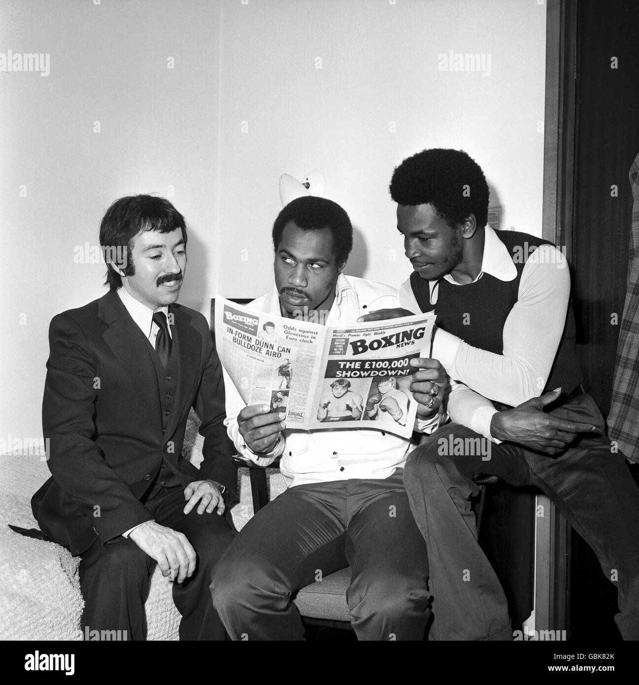 Boxen. Ken Norton (c) liest die Boxing News mit dem Herausgeber Graham Houston (l) und Hedgemon Lewis (r) Stockfoto