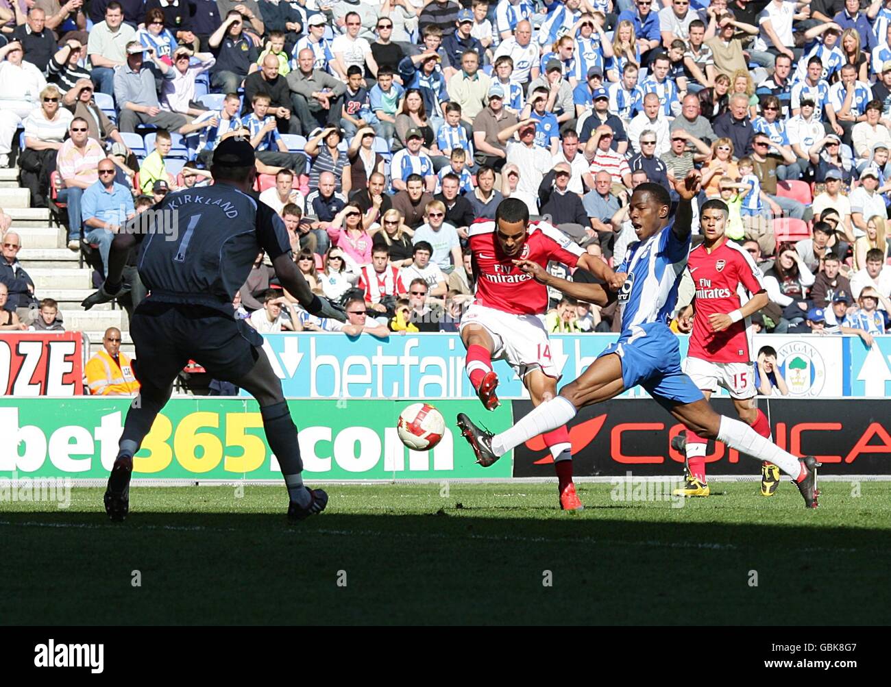 Theo Walcott (Mitte) von Arsenal punktet mit dem Ausgleich hinter Wigan Athletic Torwart Chris Kirkland (links) Stockfoto