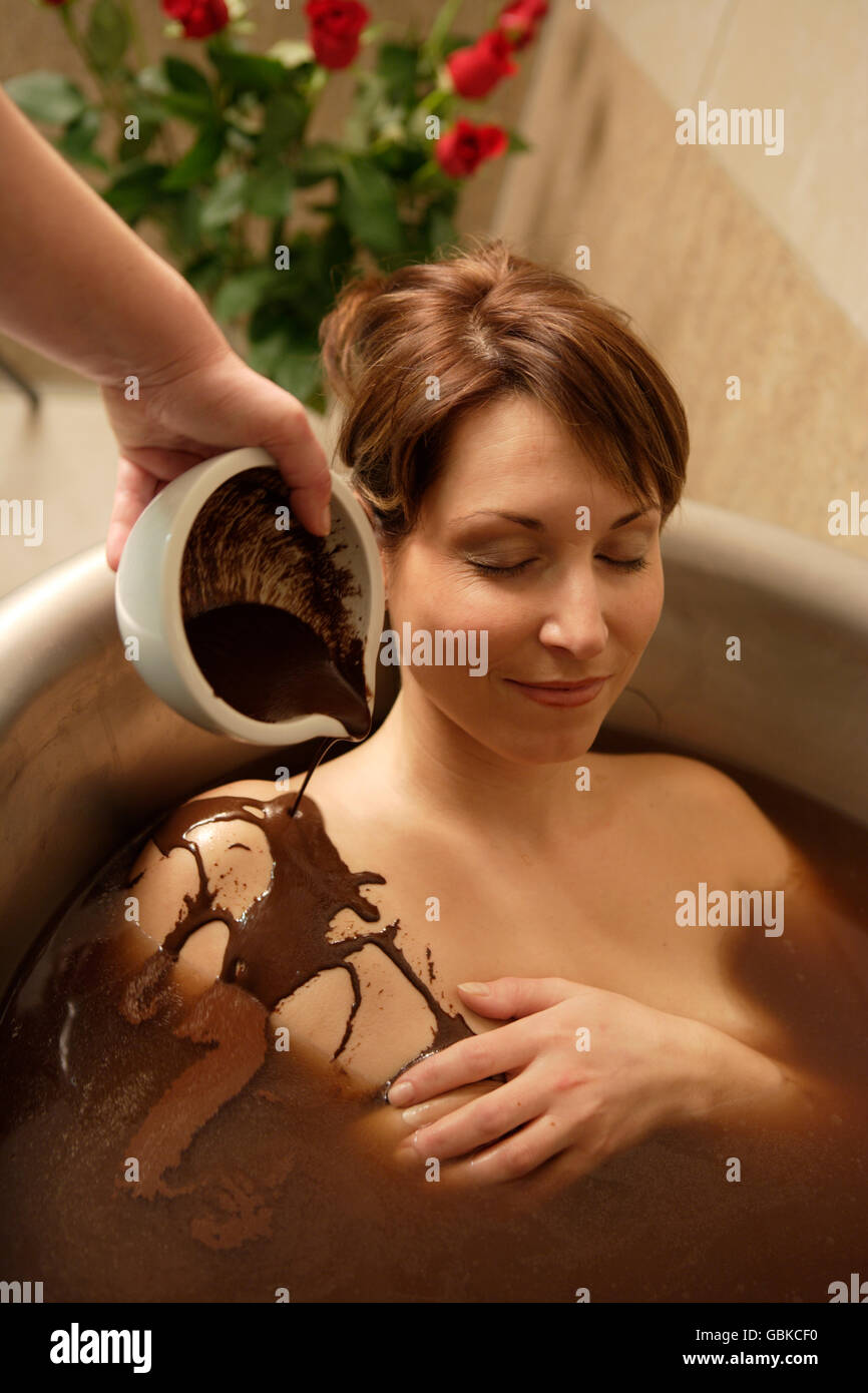 Frau, 35, in einer Badewanne mit Schokolade, Thalasso-Therapie in einem Kurort Stockfoto