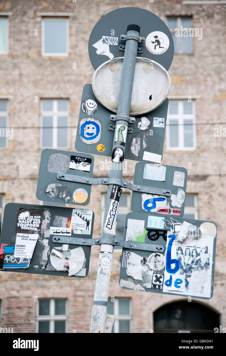 Verkehrszeichen, die von hinten gesehen mit Aufklebern vor der Fassade eines Gebäudes auf Oranienburgerstraße, Berlin Stockfoto