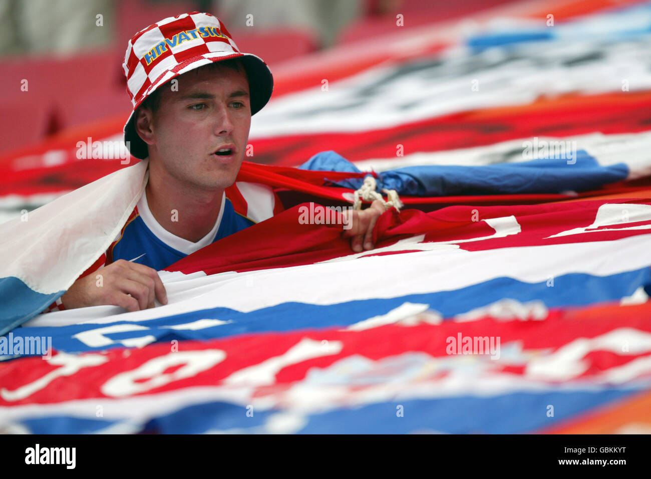 Fußball - UEFA-Europameisterschaft 2004 - Gruppe B - Kroatien gegen England. Ein Kroatien-Fan versucht, seinen Platz unter den Fanflaggen zu finden Stockfoto