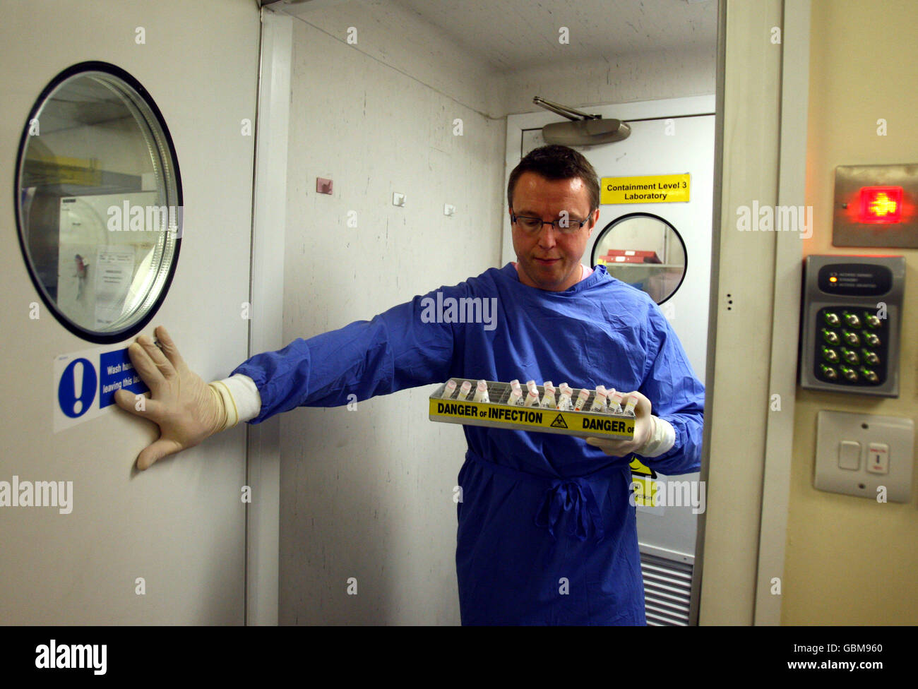 Ein Wissenschaftler behandelt Virusproben im West of Scotland Specialist Virology Centre am Gartnavel General Hospital, Glasgow, wo er Grippeproben auf Spuren der Schweinegrippe untersucht hat. Stockfoto