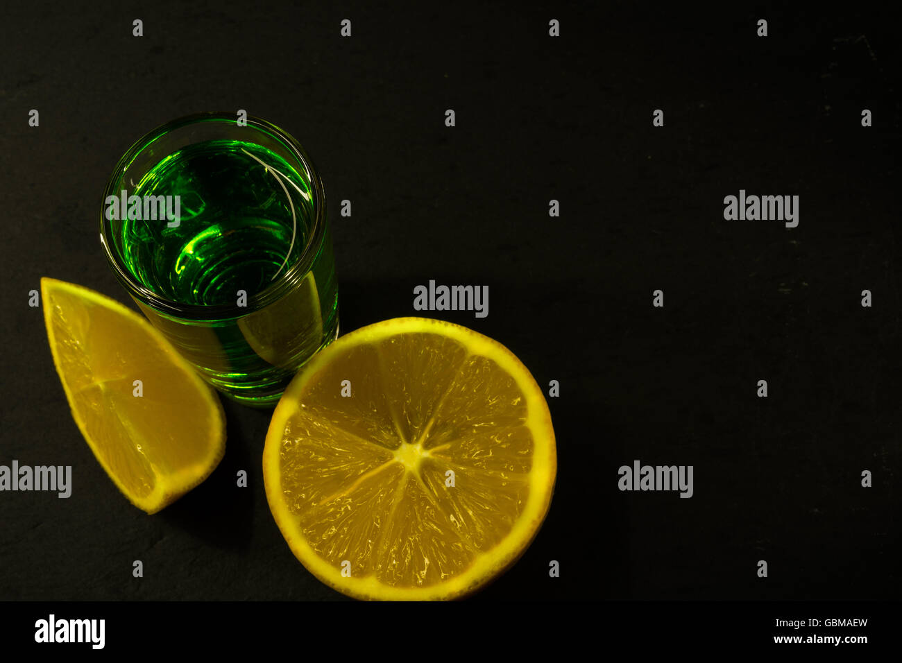 Absinth und Zitrone auf schwarzem Hintergrund. Alkohol trinken. Grüne Alkohol trinken Stockfoto