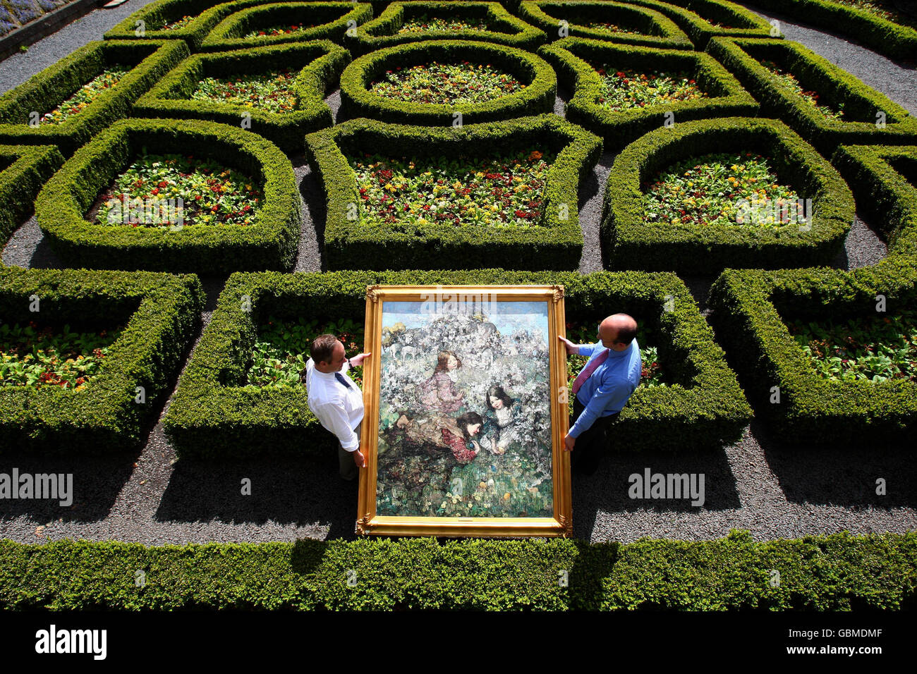 Lyon und Turnbull Staff, Campbell Armor und Gavin Strang (r) halten "Easter Eggs", ein Gemälde des Glasgow Boys Künstlers Edward Hornel, in den Gärten des Pollok House in Glasgow. Stockfoto