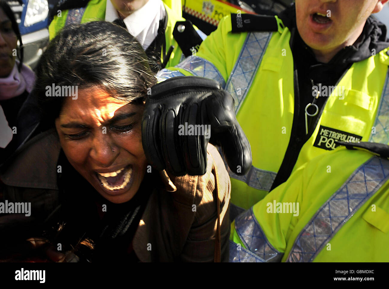 Ein tamilischer Protestler, der einen Waffenstillstand in Sri Lanka fordert, wird auf dem Parliament Square im Zentrum von London von der Polizei konfrontiert. Stockfoto