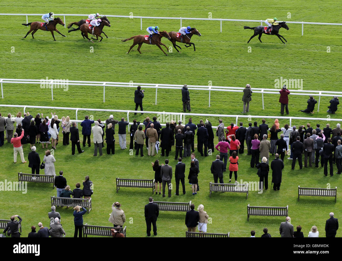 Eine allgemeine Ansicht, während die Rennfahrer Sam Sharp im Sattel von Tom Queally (rechts) beobachten, wie er auf der Rennbahn Newbury Racecourse in Bekshire die Bathwick Tyres Maiden Stakes gewinnt. Stockfoto