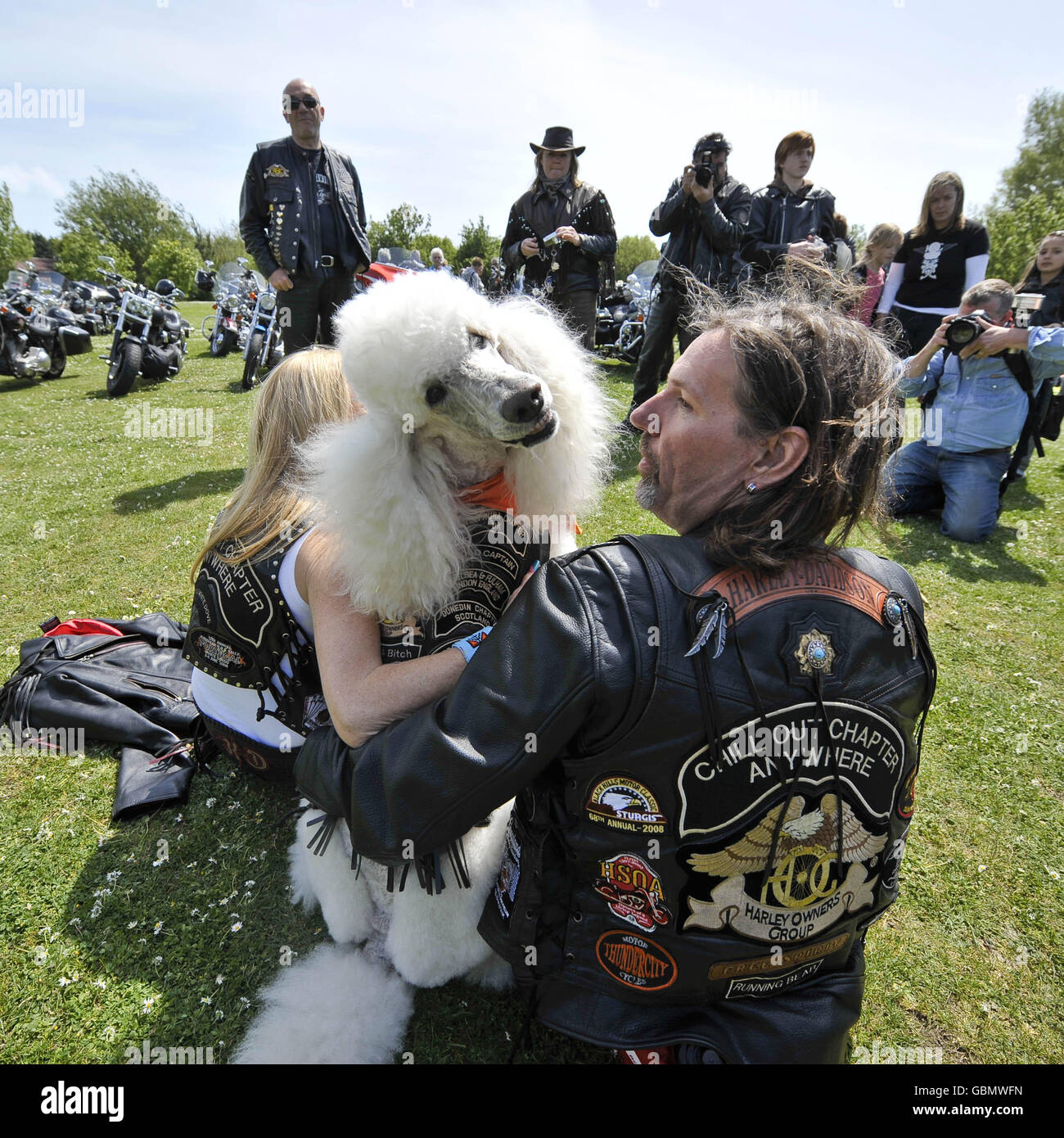 Oliver, der Pudel, in seiner Bikerjacke gekleidet, mit seinem Besitzer Robert Gunson aus Sheffield, im Lodmoor County Park, Warmwell Leisure Center, Warmwell, in der Nähe von Dorchester, Dorset während der jährlichen Fahrradtour der Harley Davidson Owners Group treffen sich Mitglieder. Stockfoto