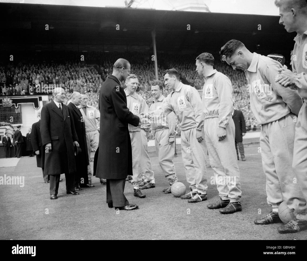 S.H. der Herzog von Edinburgh (siebte R) schüttelt sich die Hände mit Allan Brown von Luton Town (vierte R), als Luton-Kapitän Syd Owen (sechste R) vor dem Spiel sein Team den Würdenträgern vorstellt. Looking On is Lutons Billy Bingham (fünfte R) Stockfoto