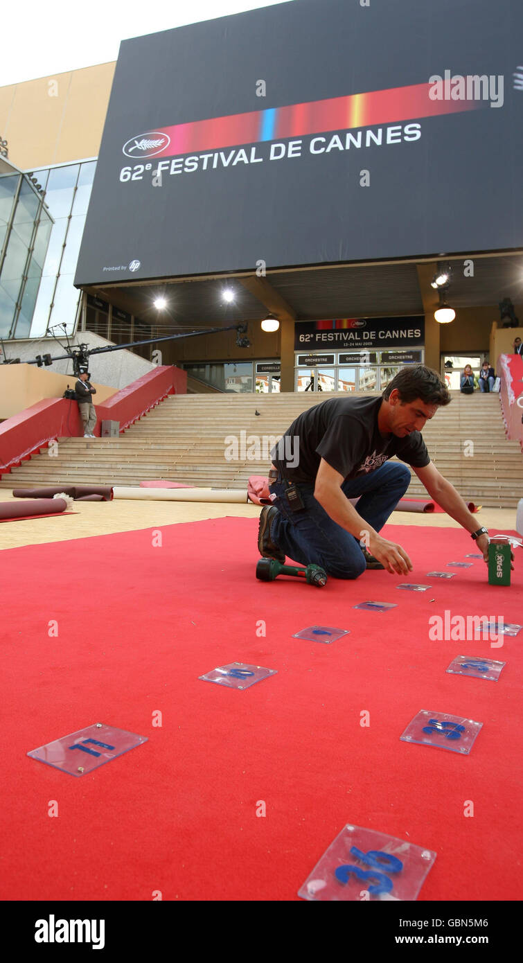 Die Arbeiter setzen Zahlen, um die Positionen der Fotografen zu markieren, während sie den roten Teppich vor dem Palais des Festivals in Cannes, Frankreich, vorbereiten, bevor das 62. Festival de Cannes, das morgen beginnt, beginnt. Stockfoto