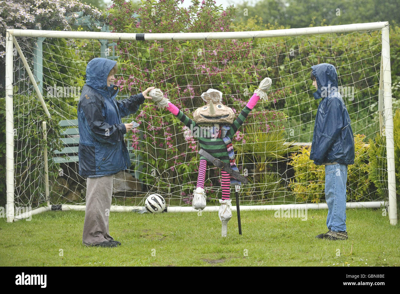 Die Menschen trotzen dem Regen, um an einem Vogelscheuchen-Pfad im Dorf Norton St. Philip, Somerset teilzunehmen und die Vogelscheuche Nummer 12, Spud, abzuhaken, da alle Vogelscheuchen-Charaktere auf Fernsehfiguren von Kindern basieren. Stockfoto