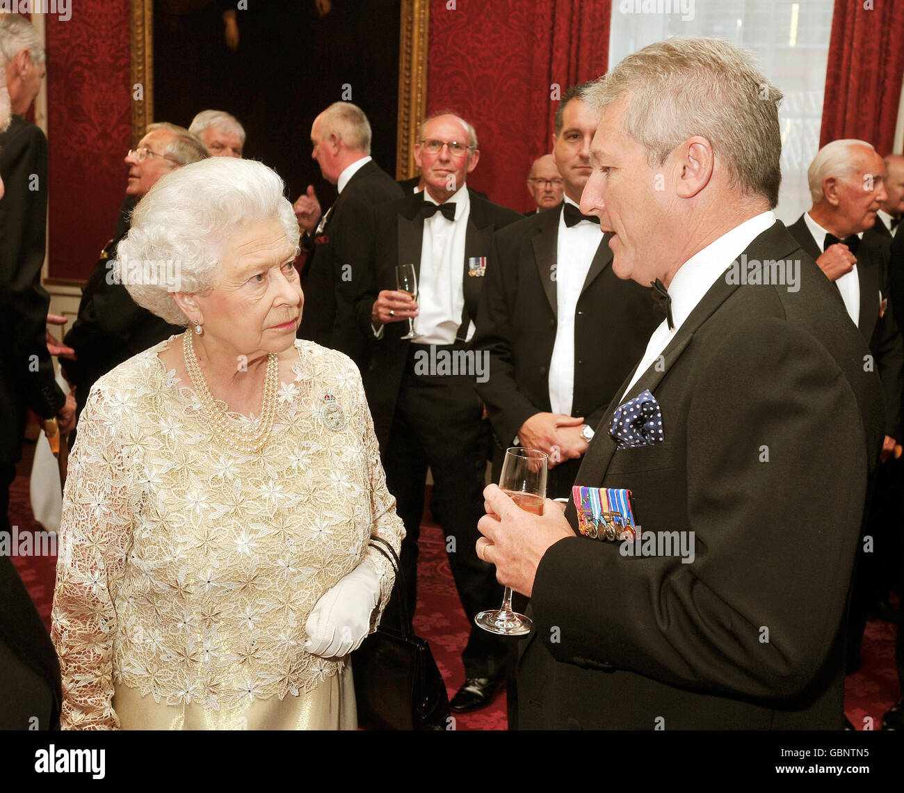 Die Königin spricht mit Col Tim Collins, der vor der Invasion des Irak im Jahr 2003 eine inspirierende Rede vor seinen Truppen hielt, beim Empfang der Riding Masters, Quatermasters und Directors of Music Association im St. James's Palace in London. Stockfoto