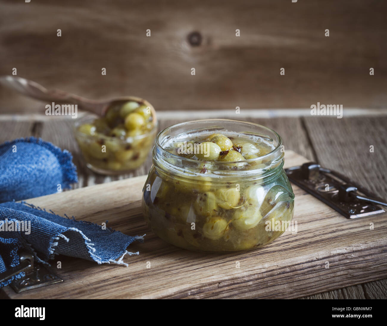 Hausgemachte Bio-Beeren Marmelade, Stachelbeere Gelee in Glas auf rustikalen Holztisch Stockfoto