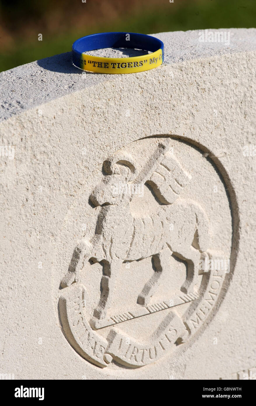 Eine Marke, die auf einem Grabstein auf dem Bayeux-Kriegsfriedhof zurückgelassen wurde, während sich Veteranen der D-Day-Landungen in Nordfrankreich zu Gedenkfeiern zum 65. Jahrestag versammeln. Stockfoto
