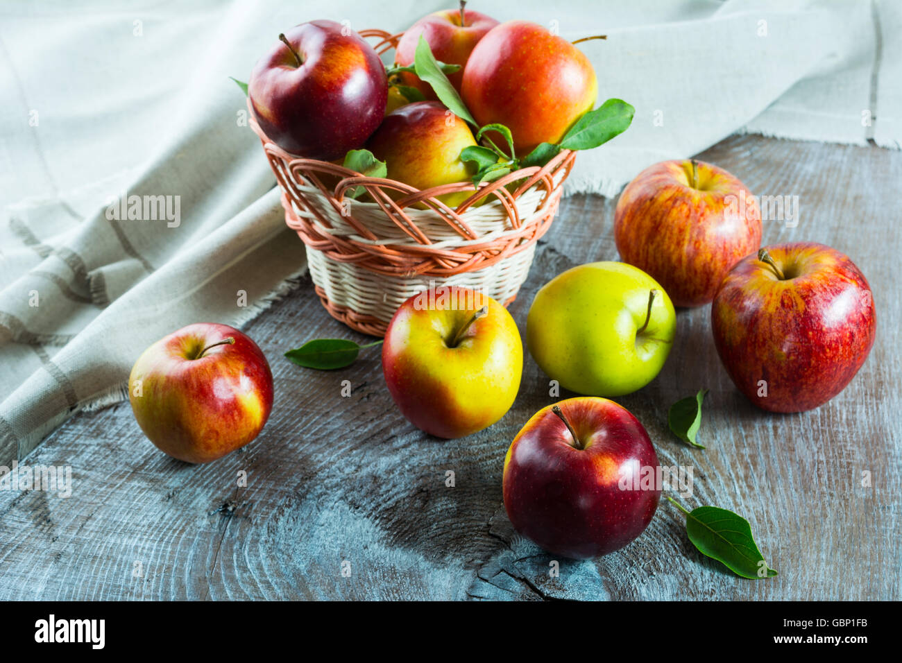 Die Reifen Äpfel im Korb auf dem Holztisch. Frisches Obst. Frische Äpfel. Gesunde Ernährung. Gesunde Ernährung. Vegetarisches Essen. Stockfoto