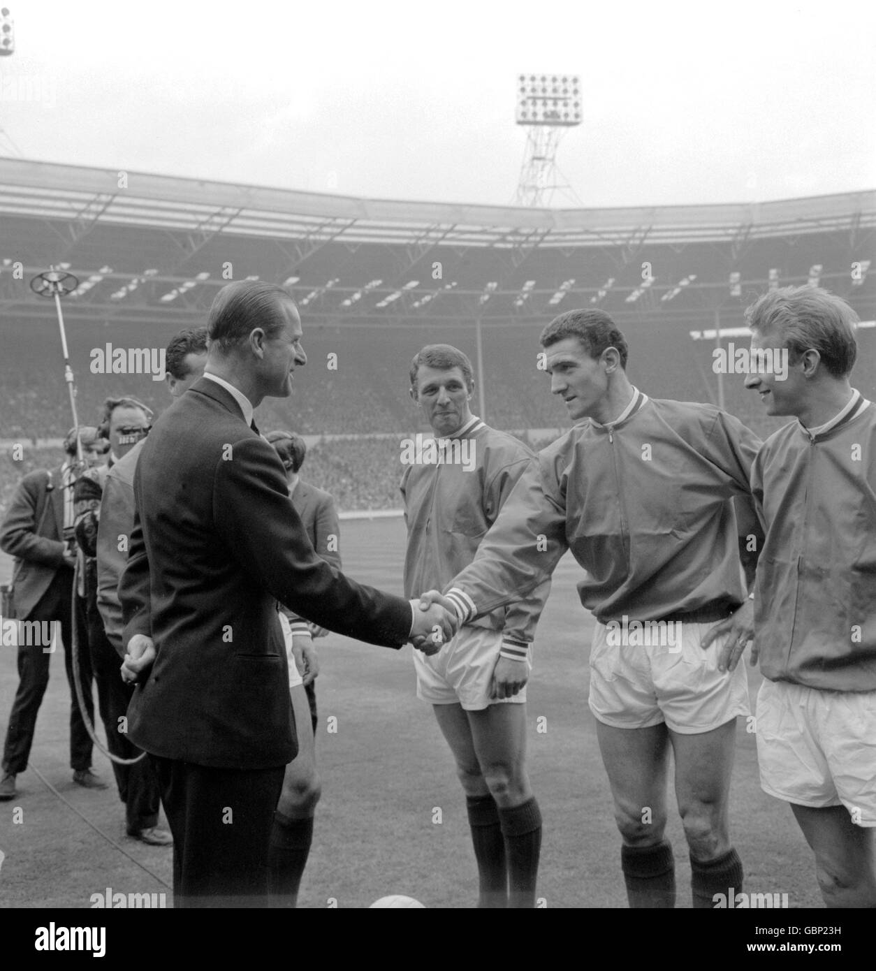 HRH der Duke of Edinburgh (l) schüttelt sich die Hände gegen Bill Foulkes von Manchester United (zweite R), als United Kapitän Noel Cantwell (l, versteckt) sein Team vor dem Spiel präsentiert. Im Blick stehen Denis Law (r) und David Herd (dritte r) von United. Stockfoto