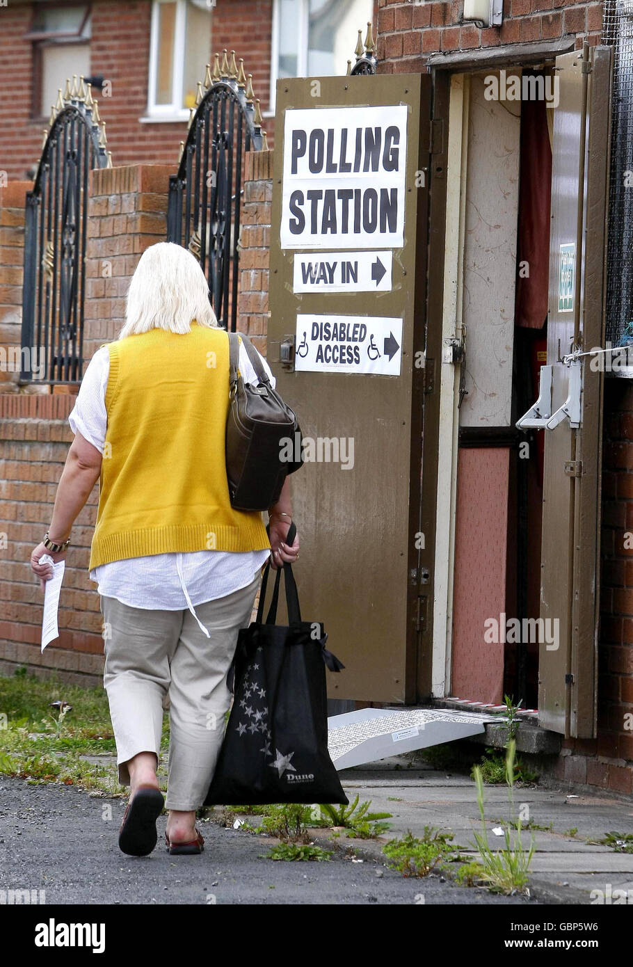 Eine Frau kommt in einem Wahllokal in Halewood, Liverpool, an, um an den lokalen und Europawahlen teilzunehmen. Stockfoto