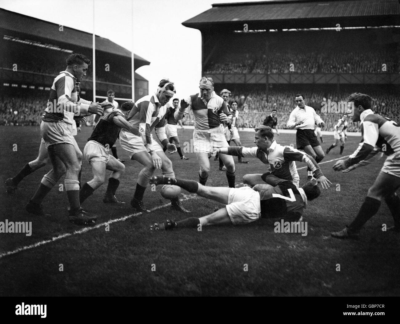 Dickie Jeeps, Kapitän von England und Wales, übergibt den Ball an Muscles Currie, während er von Andy Mulligan aus Schottland und Irland angegangen wird. Stockfoto