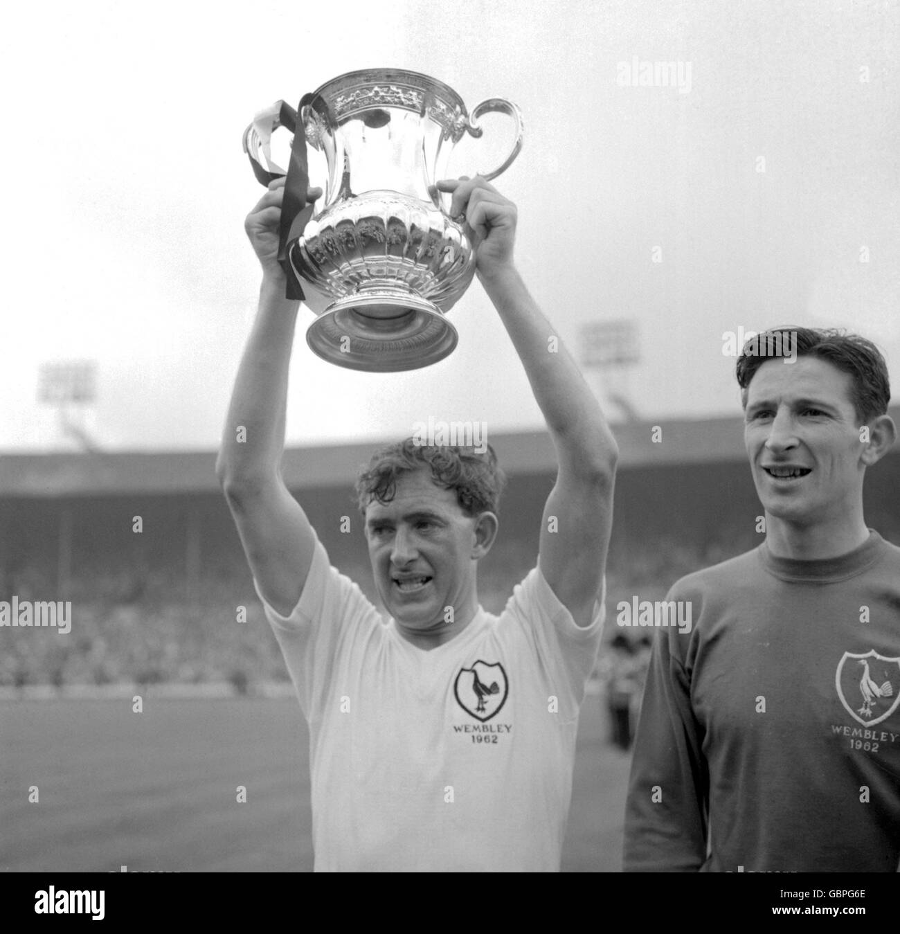 Tottenham Hotspur Kapitän Danny Blanchflower hält den FA Cup hoch Nach dem Sieg seines Teams im Jahr 3-1 als Teamkollege Bill Brown (r) Beobachtet die Reaktion der Menge Stockfoto