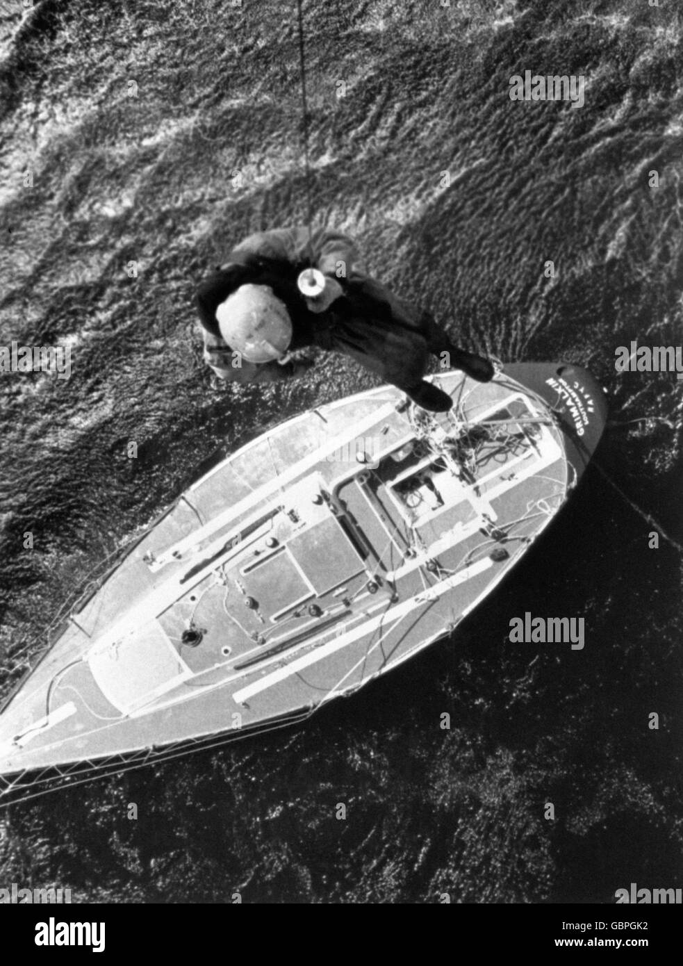 Ein Hubschrauber-Crewman hängt an einer Winde, um die zerschlagene Yacht Grimalkin nach dem Fastnet-Rennunglück auf mögliche Überlebende zu überprüfen. Stockfoto