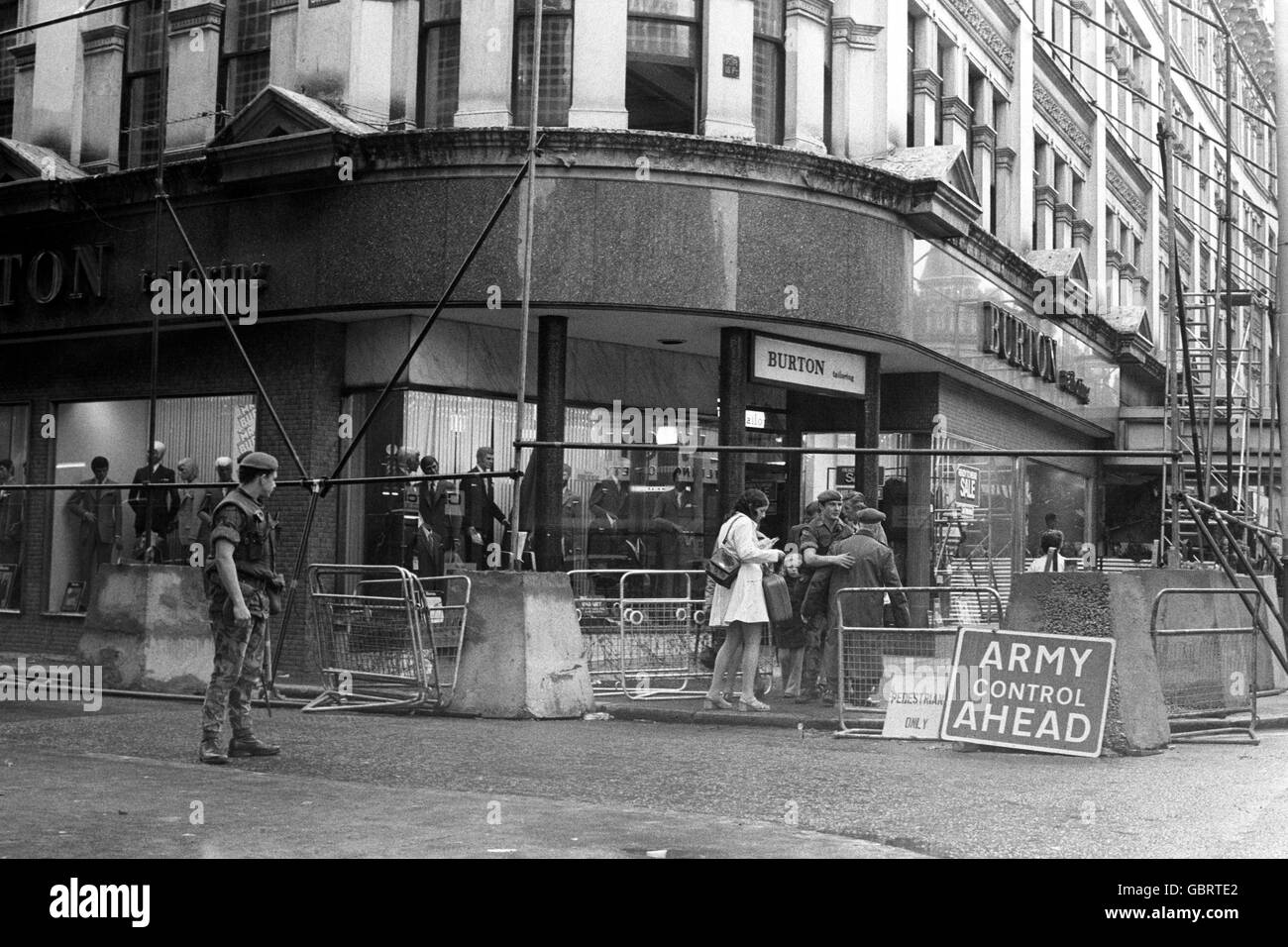 Die Käufer werden heute im Zentrum von Belfast gesehen, wo sie von Truppen kontrolliert und durchsucht werden. Ein Warnhinweis weist Fußgänger darauf hin, dass die Armeekontrolle im Herzen des Einkaufszentrums der Stadt tätig ist. Stockfoto