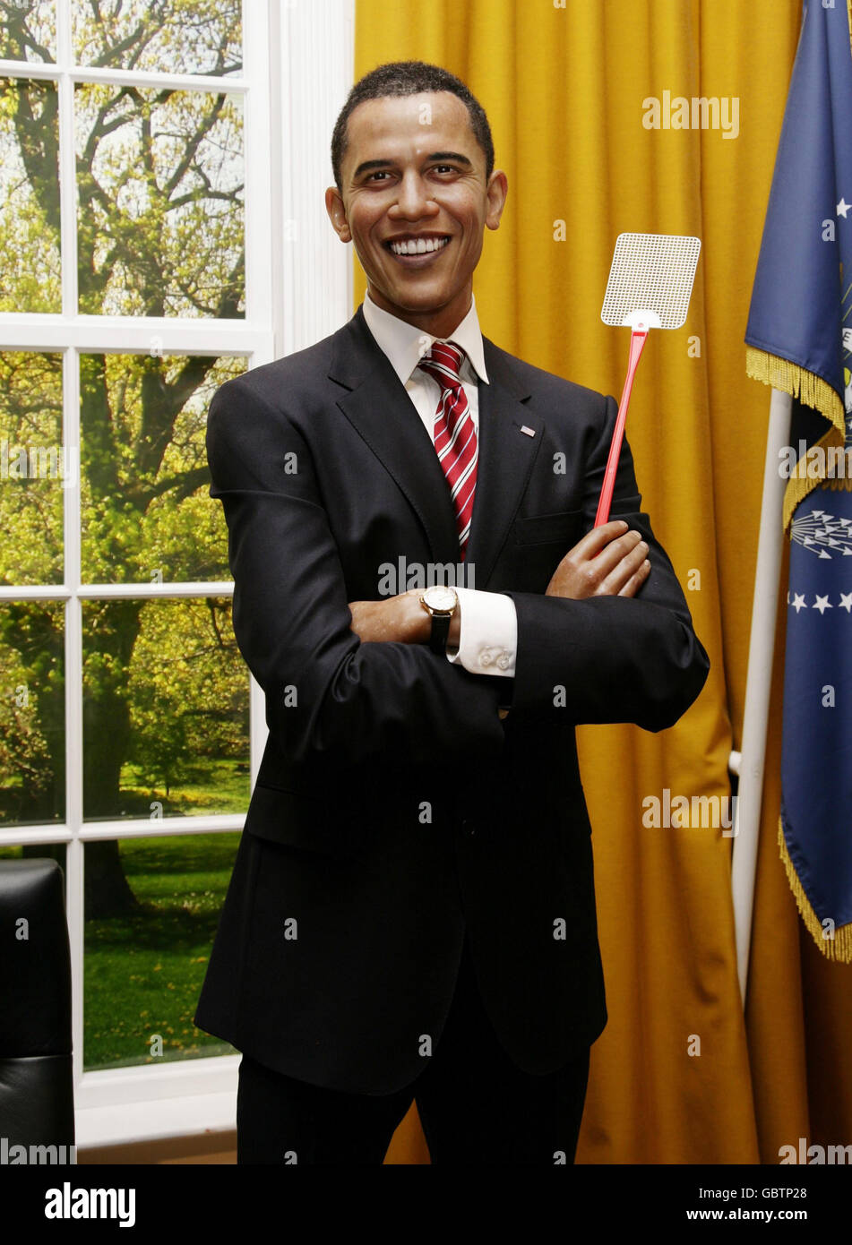 Ein Wachsmodell von Präsident Obama ist mit einer Fliege swat ausgestattet, bei Madame Tussauds im Zentrum von London. Stockfoto