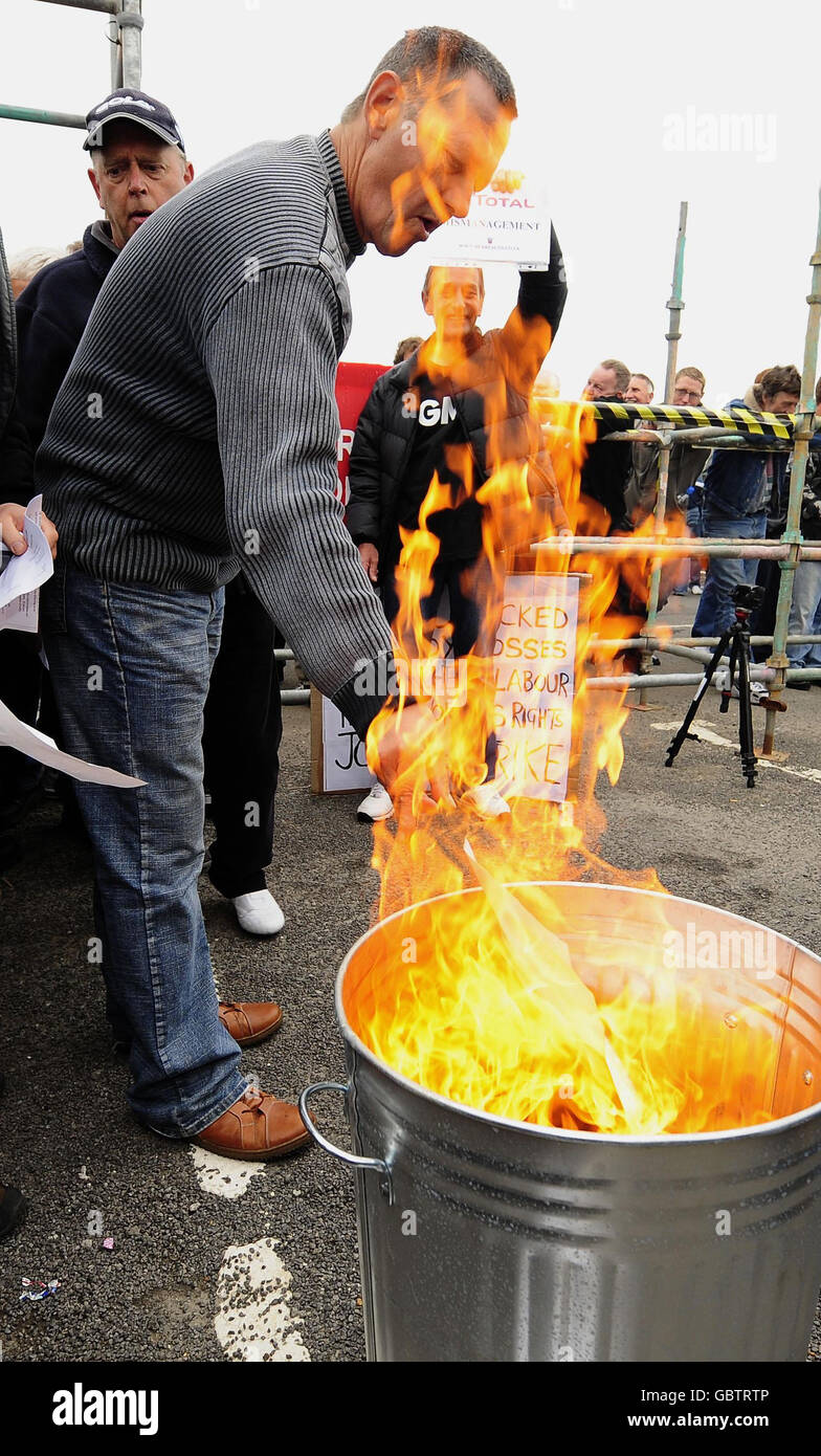 Bauarbeiter verbrennen ihre Kündigungsschreiben vor der Ölraffinerie Lindsey in einem Akt des Trotzes gegen den französischen Ölgiganten Total. Stockfoto