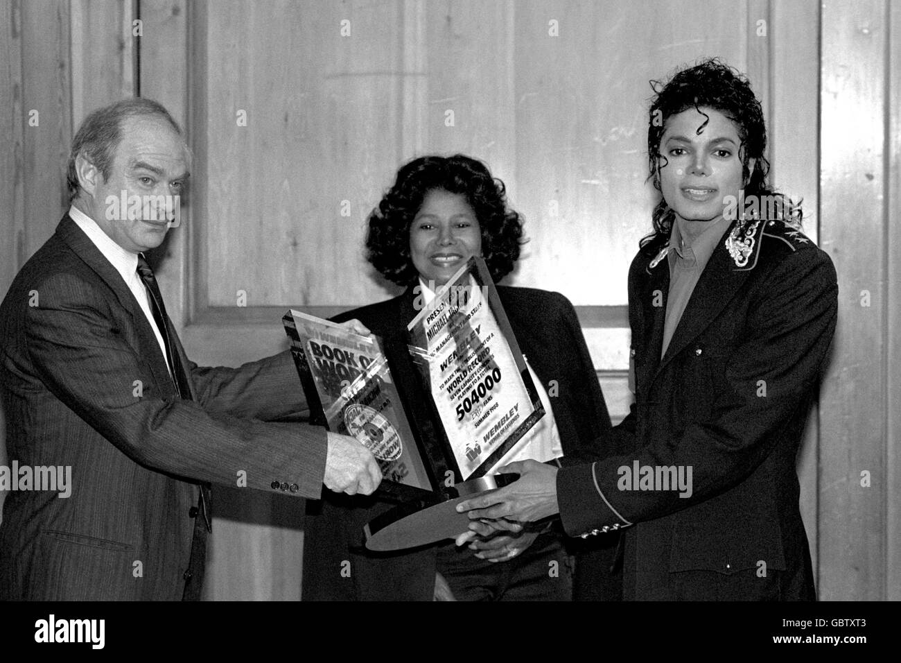 Brian Wolfson, Vorsitzender des Wembley Stadions, überreicht Popstar Michael Jackson eine besondere Auszeichnung, um die sieben ausverkauften Shows des Sängers in Wembley während seiner UK-Tournee zu markieren. Die Mutter des Stars, Katherine Jackson, beobachtet die Präsentation im Londoner Mayfair Hotel. Stockfoto