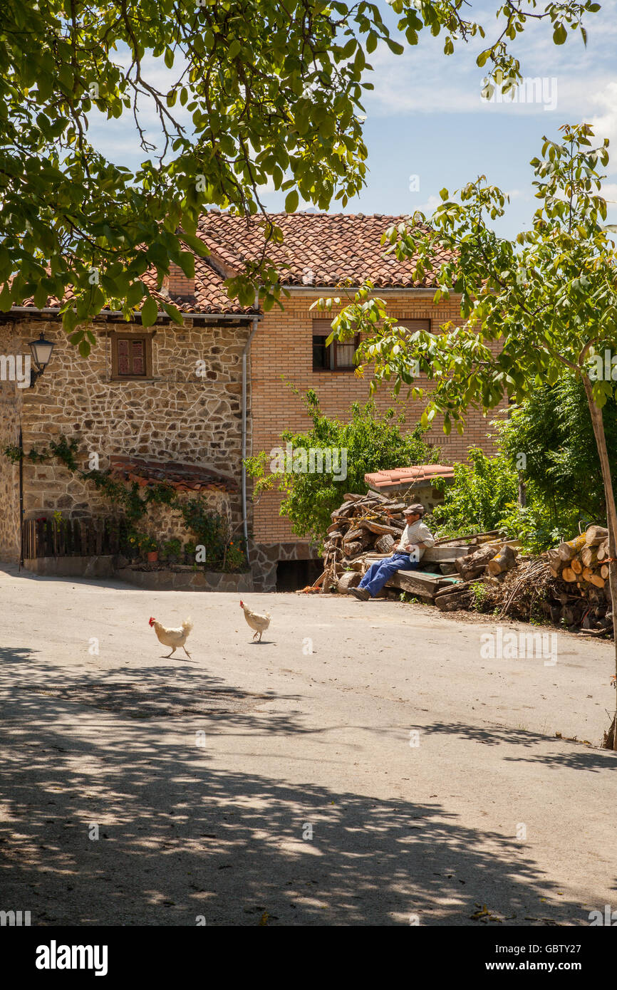 Spanische Bauern sitzen mit Hühner laufen frei im Hof Stockfoto