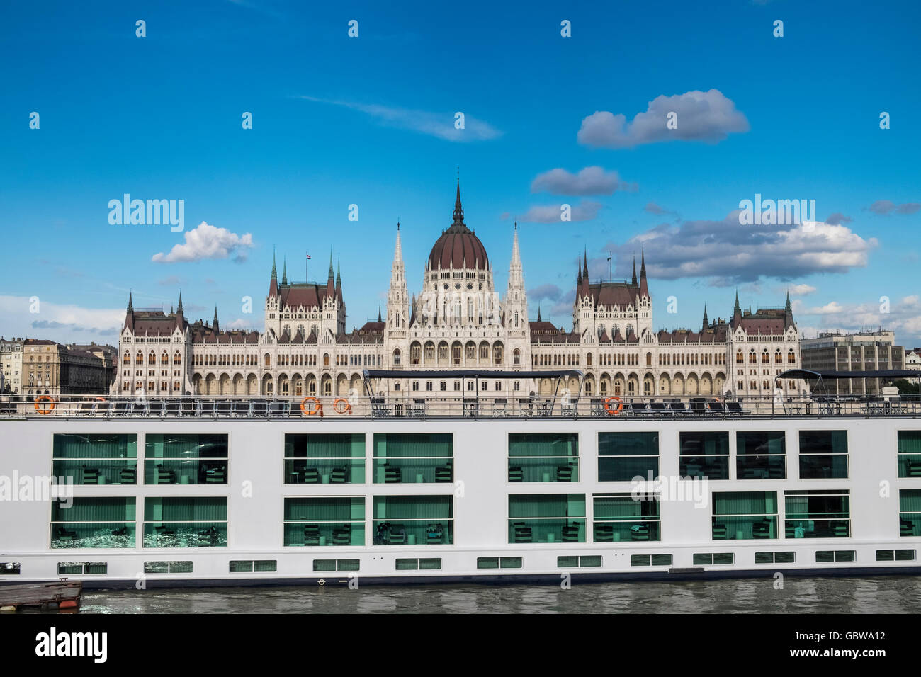 Gotische Architektur des ungarischen Parlamentsgebäude, mit Kreuzfahrt-Schiff auf der Donau im Vordergrund, Budapest, Ungarn Stockfoto