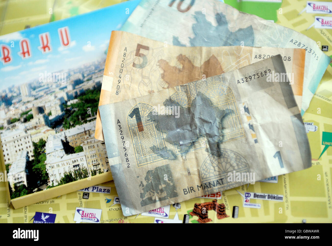 Reisestacks - Baku - Aserbaidschan. Allgemeine Ansicht der aserbaidschanischen Währung, der Manat, oben auf einer Karte von Baku, Aserbaidschan Stockfoto