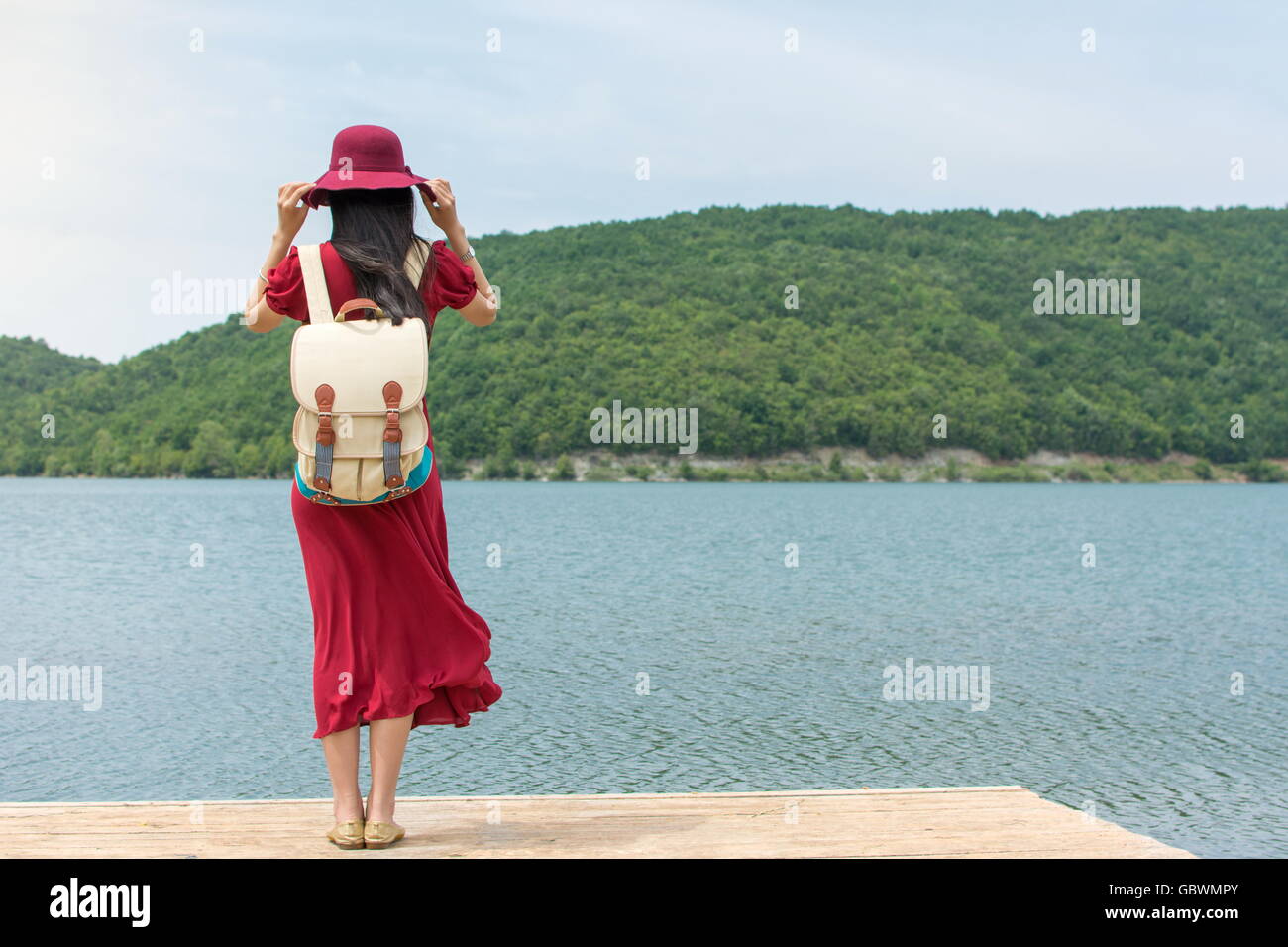 Modische Frau stand vor einem See allein Stockfoto