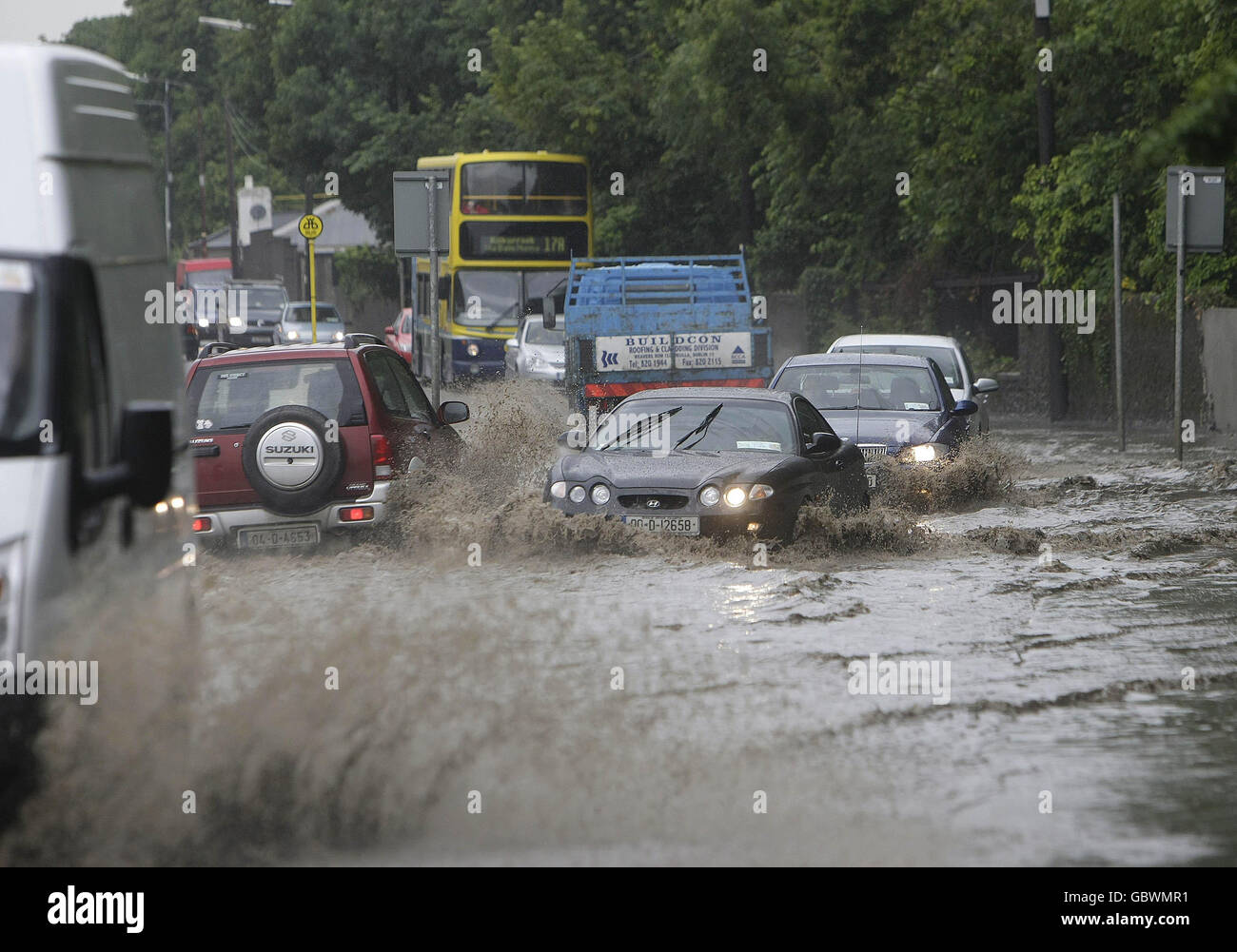 Autos machen ihren Weg durch einen überfluteten Abschnitt der Santry Avenue in Dublin. Stockfoto