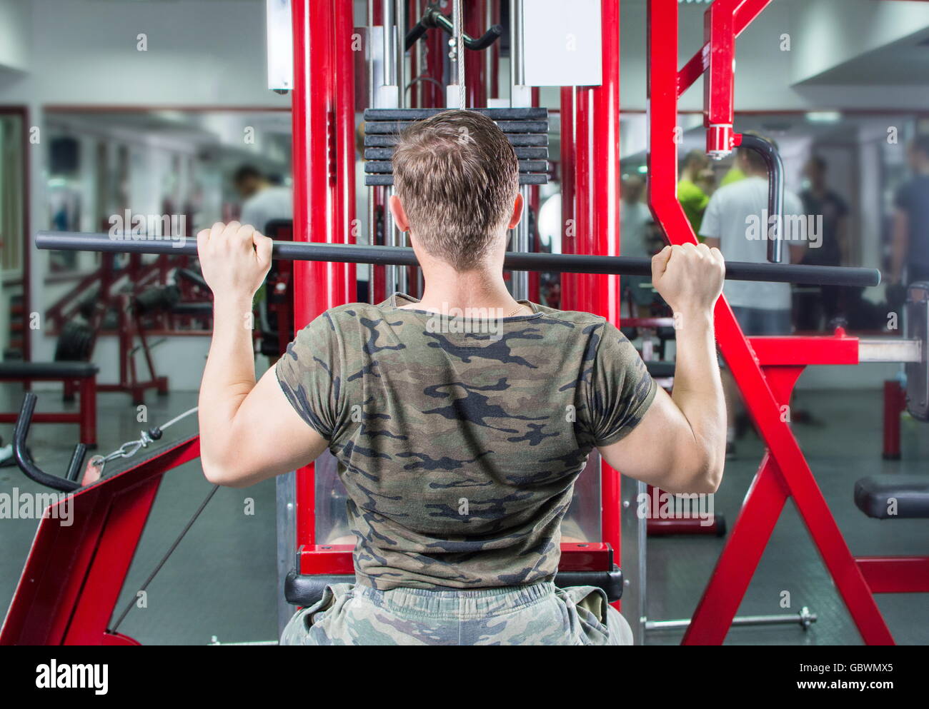 Muskulöser Mann Durchführung Lat Pulldown in der Turnhalle Stockfoto