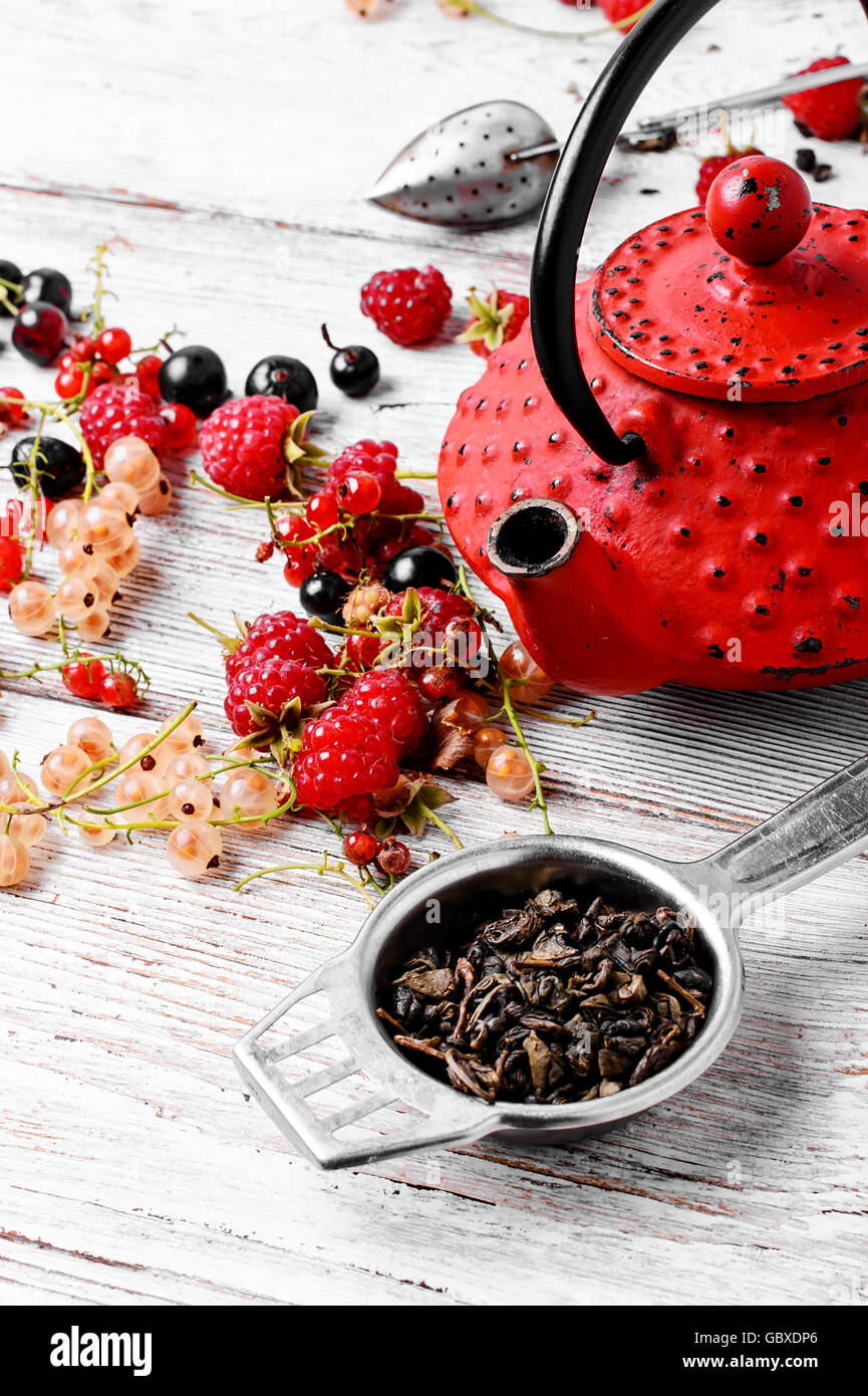 Früchtetee mit Himbeeren, Johannisbeeren im roten stilvolle Wasserkocher Stockfoto