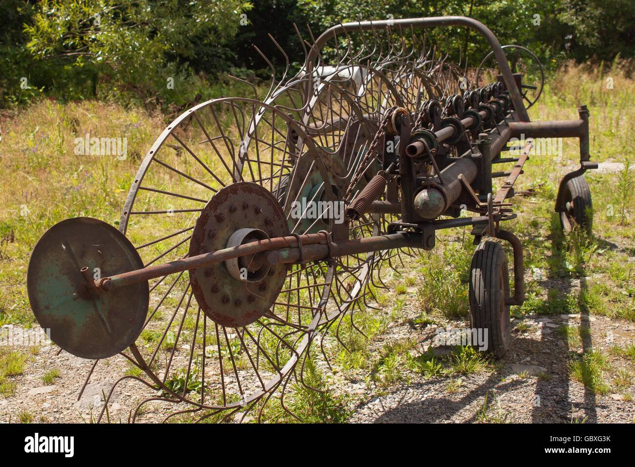 Alte rostige Heu Turner. Alte landwirtschaftliche Geräte auf Heu