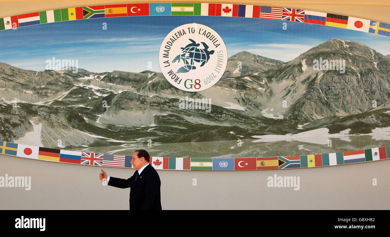 Der italienische Ministerpräsident Silvio Berlusconi verlässt die Bühne, auf der die Staats- und Regierungschefs der G8-Staaten und der G5-Staaten am zweiten Tag des G8-Gipfels in L'Aquila, Italien, für ein "Familienfoto" posieren werden. Stockfoto