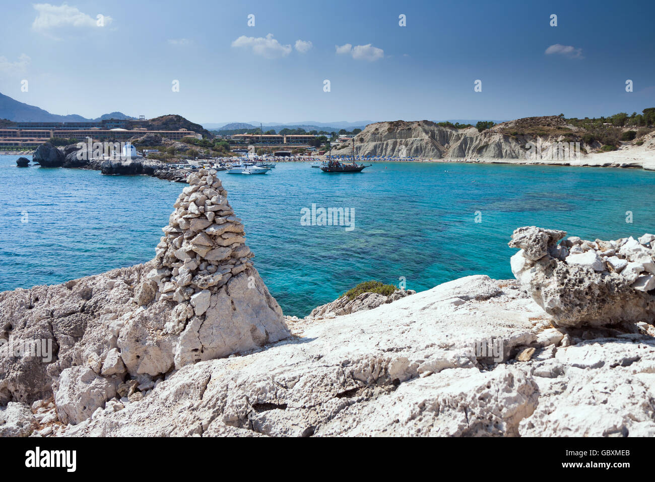 Kolymbia Beach mit der felsigen Küste in Griechenland. Kreuzfahrtschiff im Hafen kommen. Stockfoto