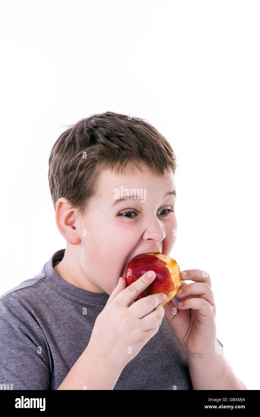 kleiner Junge mit Lebensmitteln isoliert auf weißem Hintergrund - Apfel oder ein muffin Stockfoto