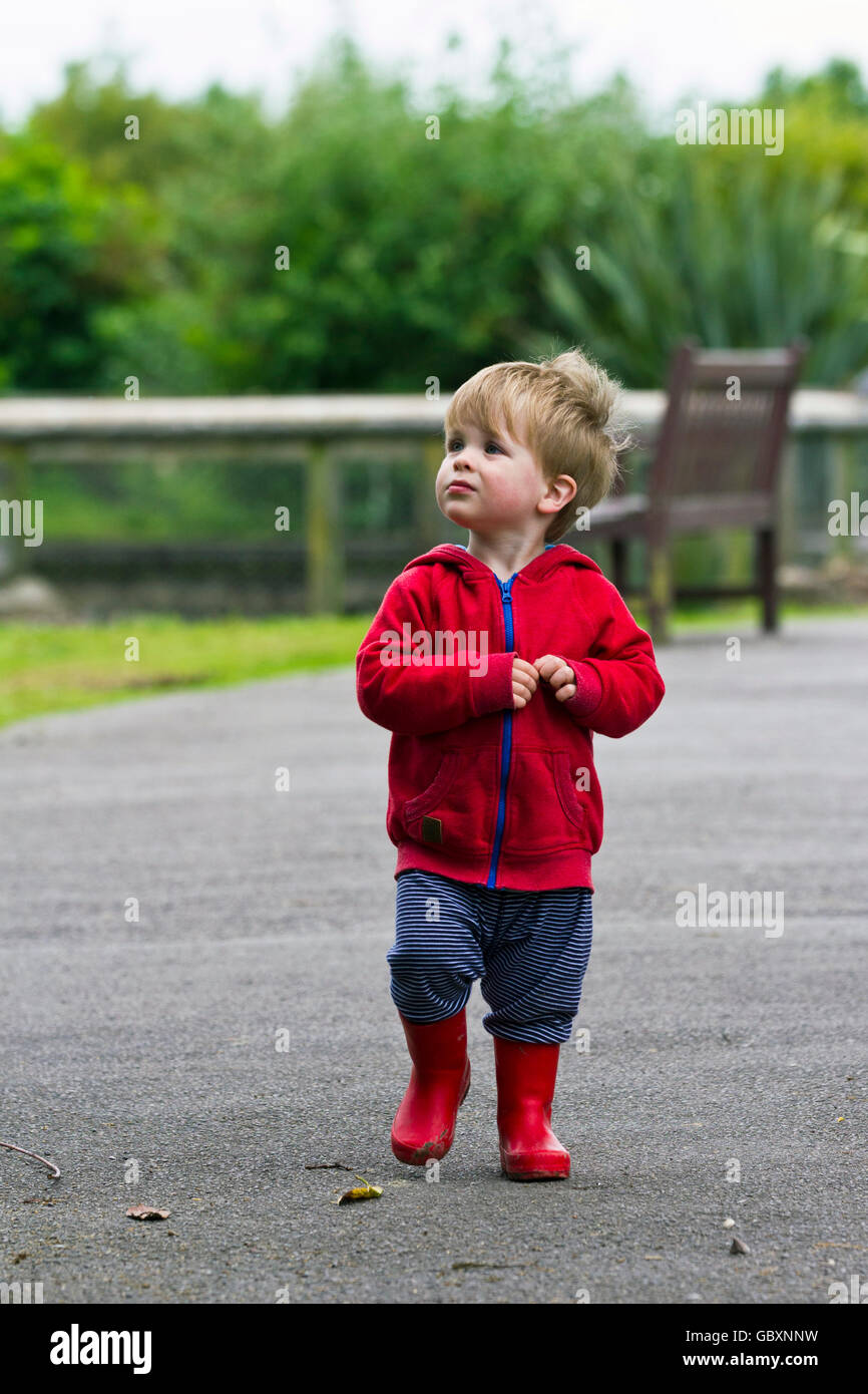 Kleinkind tragen rote Jacke und Gummistiefel Stockfoto