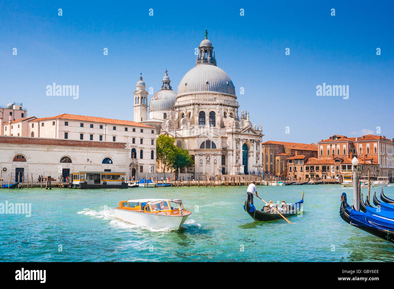 Traditionelle Gondel und Boot am Canal Grande mit historischen Basilika di Santa Maria della Salute im Hintergrund, Venedig, Italien Stockfoto