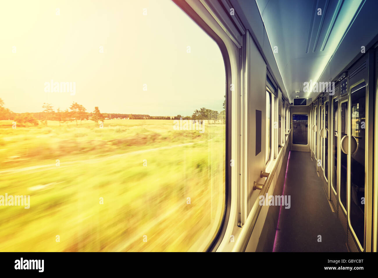 Retro-stilisierte Fensterrahmen in Zug bei Sonnenuntergang, Reisekonzept mit Bewegung verschwommen Blick nach draußen. Stockfoto