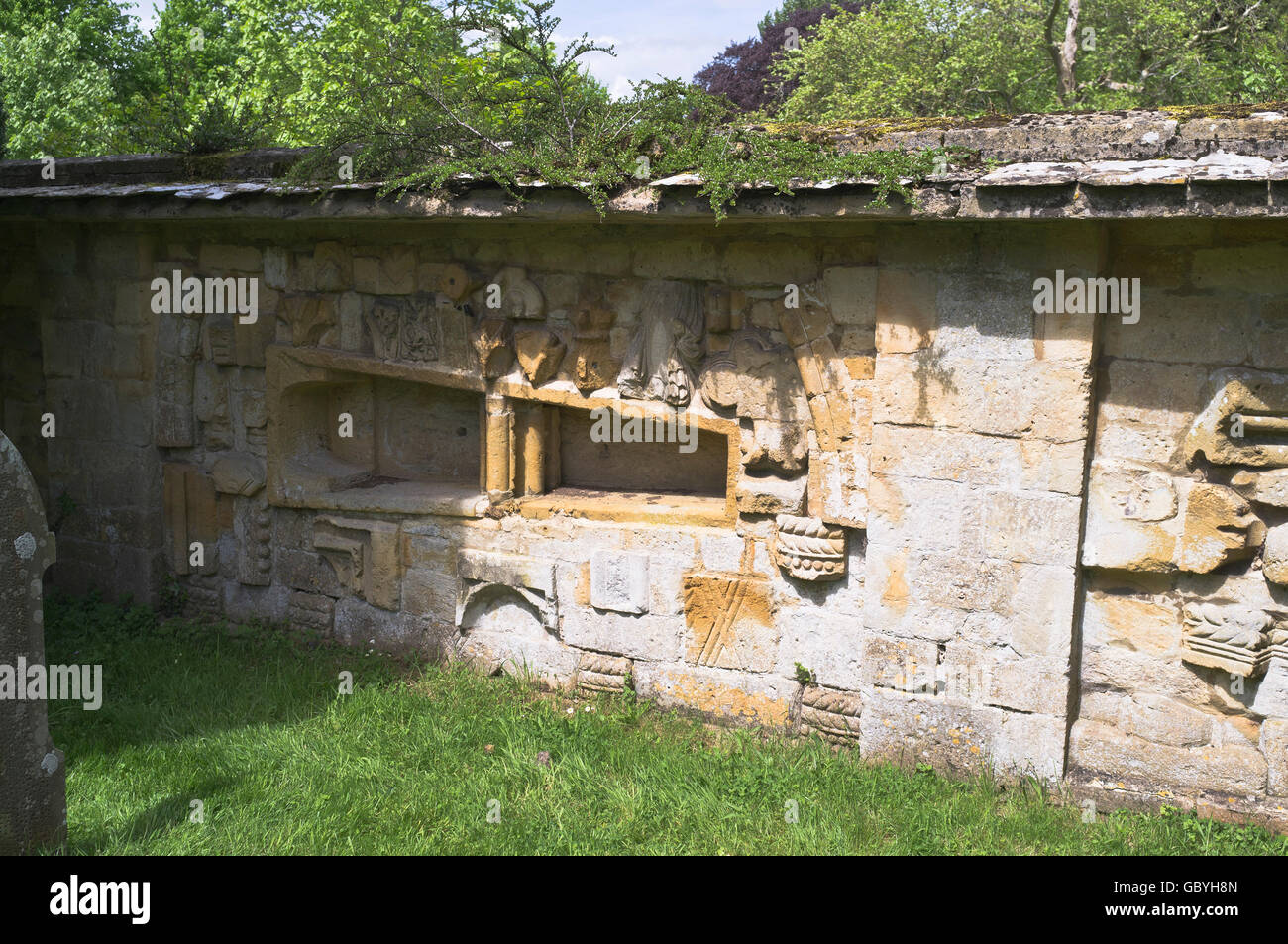 dh Stanway Kirche COTSWOLDS GLOUCESTERSHIRE Stonewall mit Steinsarg Stanway Friedhof Stockfoto