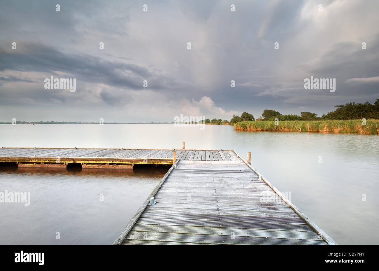 Holzsteg am großen See und wolkenverhangenen Himmel, Holland Stockfoto