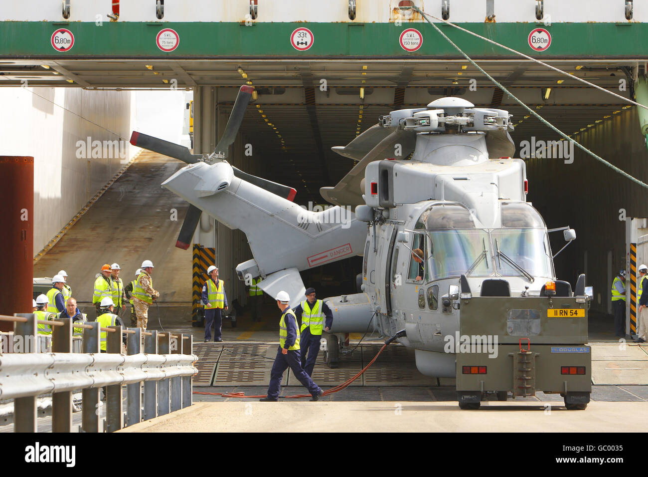 Militärangehörige des 17 Port & Maritime Regiment führen die empfindliche Operation des Abschleppens eines Merlin Hubschraubers vom modernen Logistikschiff Anvil Point am Marchwood Military Port in der Nähe von Southampton, Hampshire durch. Stockfoto