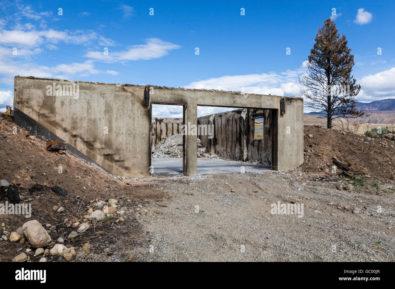 Überreste eines verbrannten Hauses in verkohlten ländlichen Landschaft nach einem Brand nach Hause. Zerstörungen durch Naturkatastrophen ein Lauffeuer. Stockfoto