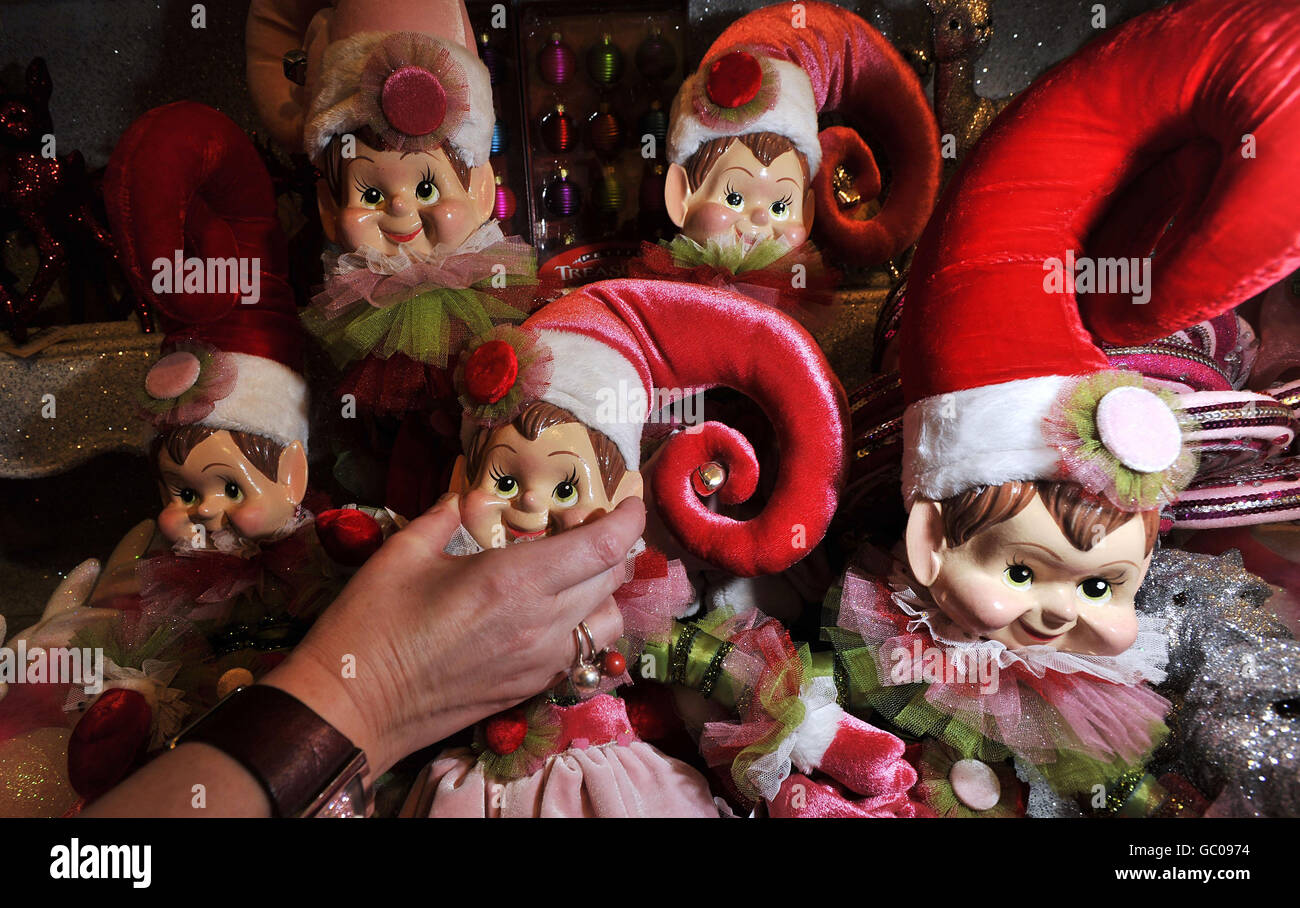 Ein Mitarbeiter hält die molligen Wangen einer Pantomime-Weihnachtspuppe im Selfridges Pantomime Christmas Shop, der heute im Untergeschoss des Kaufhauses in der Londoner Oxford Street eröffnet wurde. Stockfoto